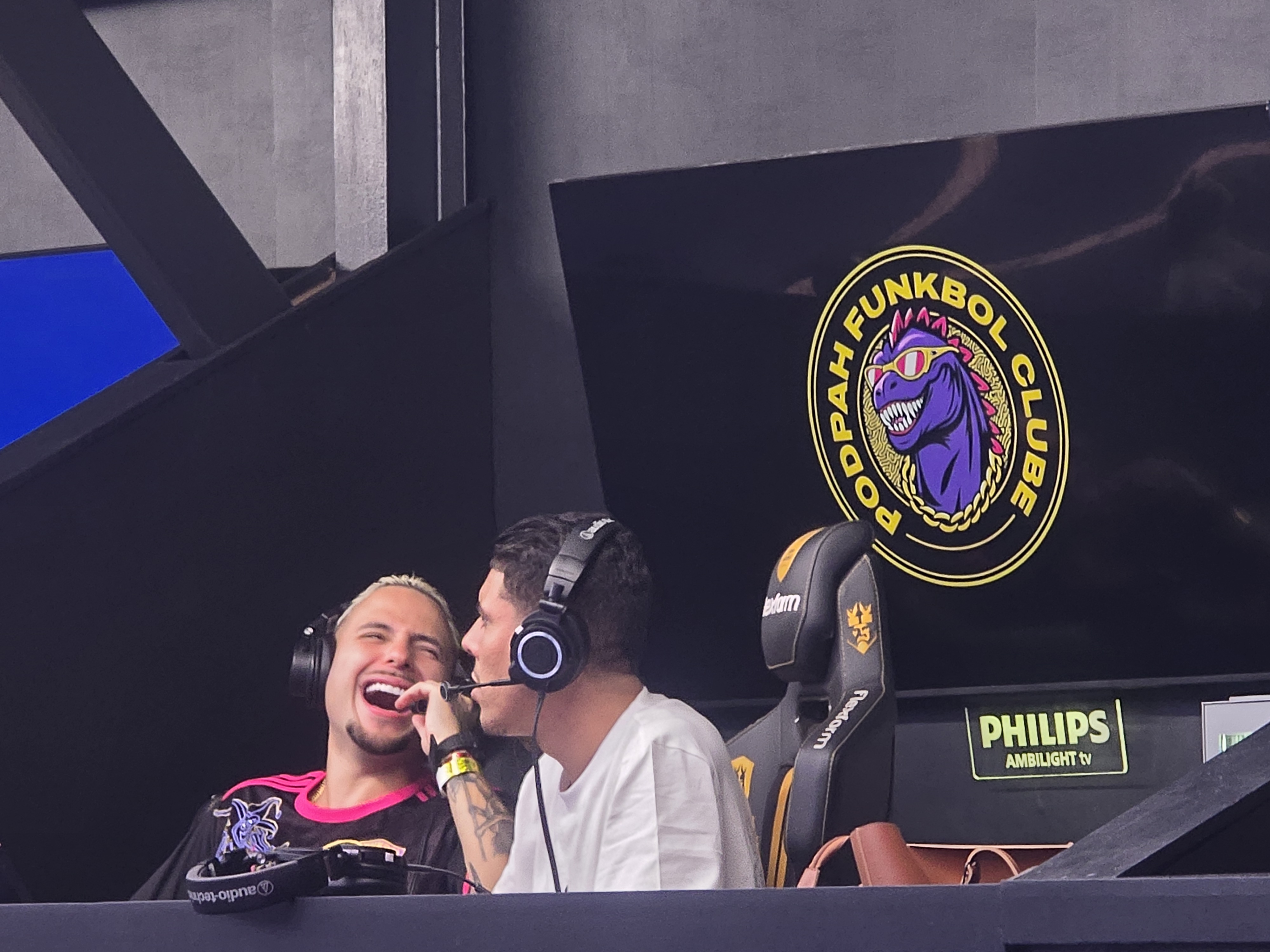 Inluenciador rindo junto de outro influenciador na cabine do time Funkbol clube