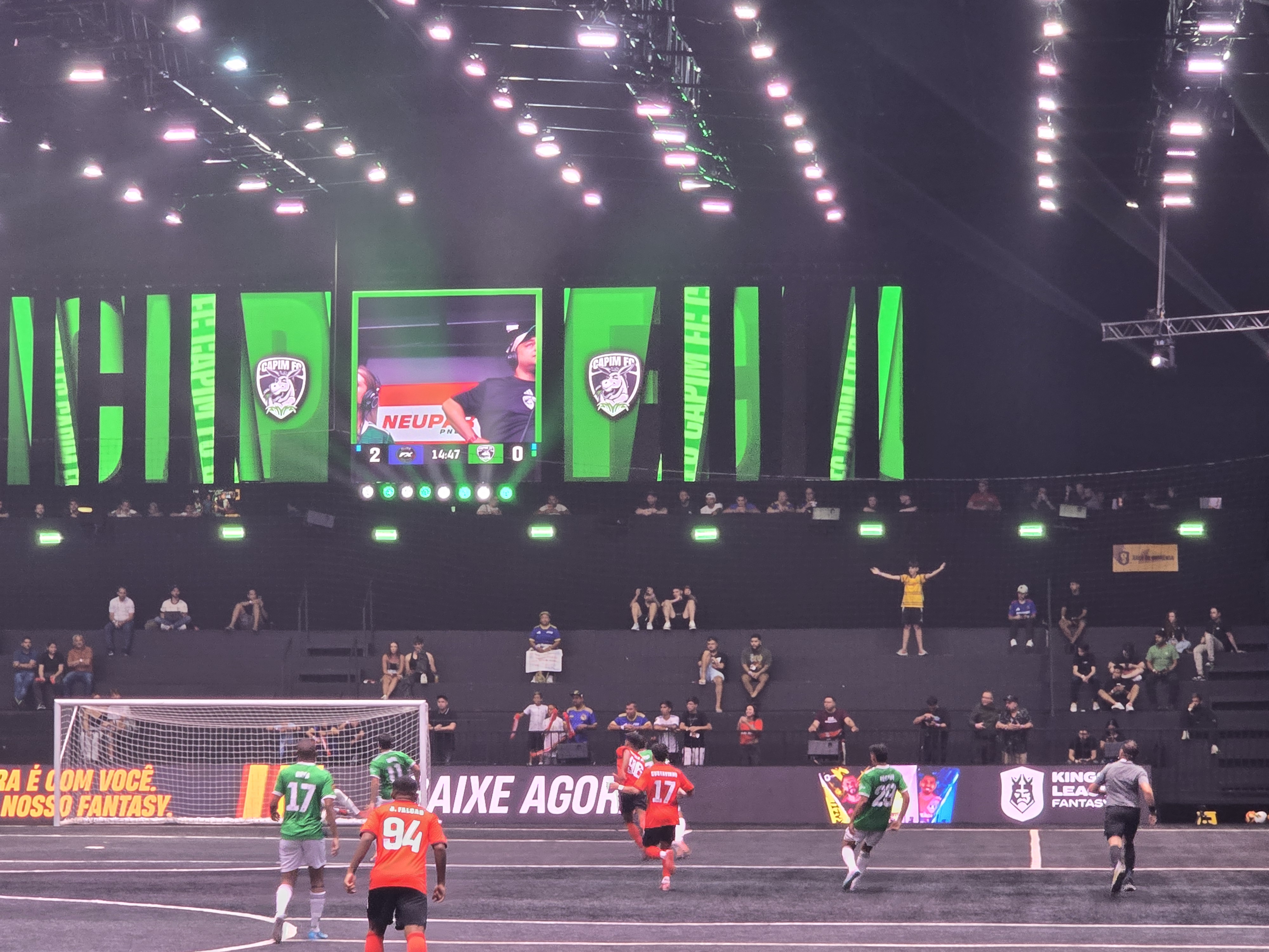 Partida entre Fluxo x Capim sendo disputada com torcida ao fundo. A partida está 2 x 0 para o fluxo