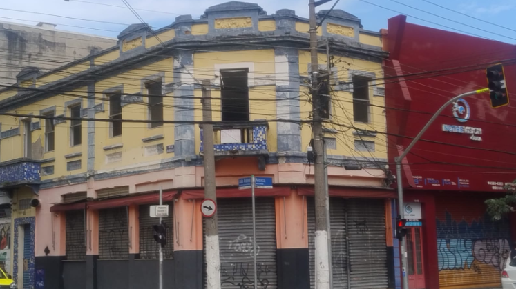 Foto de um antigo casarão de esquina na Mooca, hoje em dia, mal cuidado.