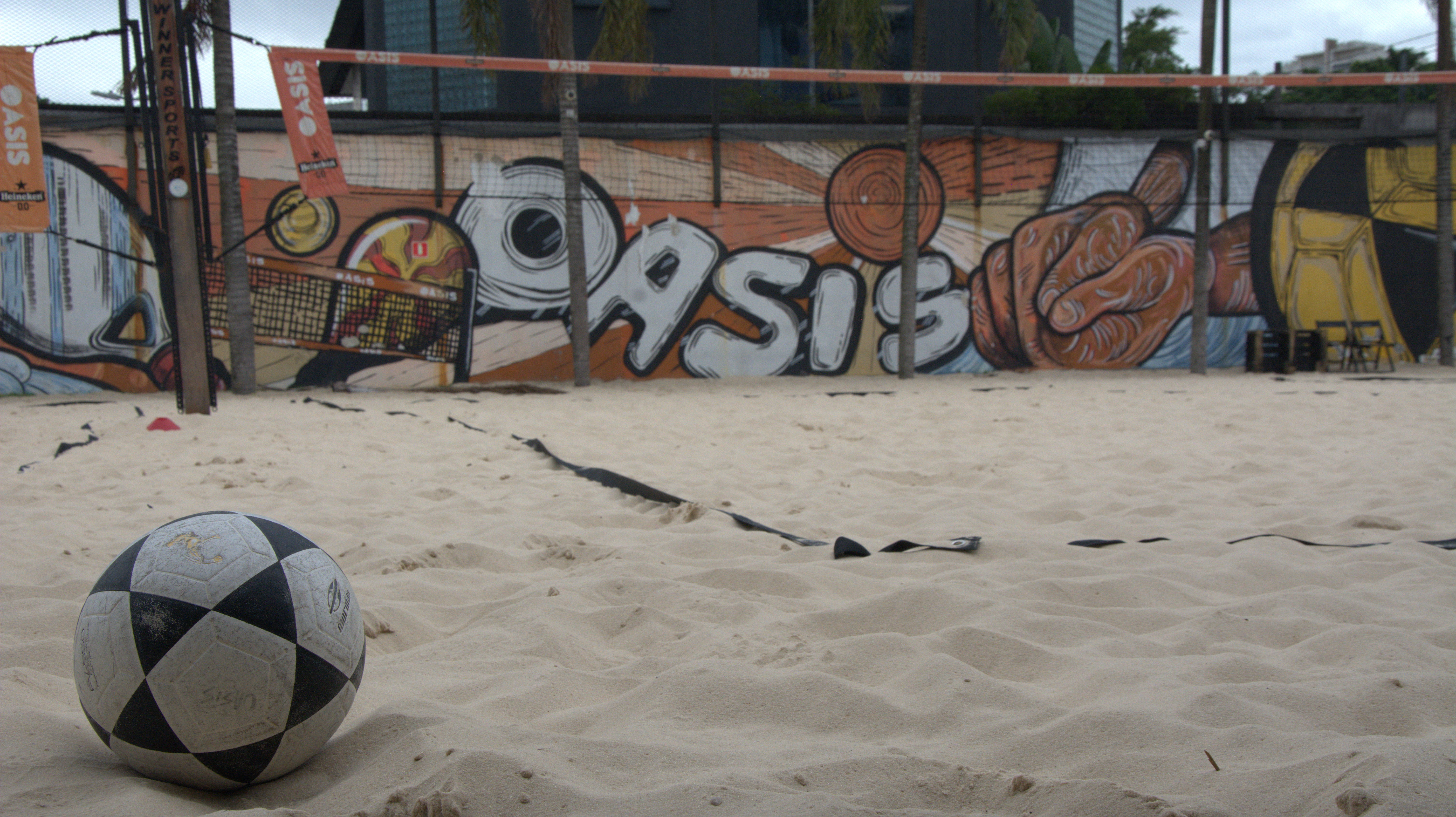 Foto de uma bola de futevôlei em uma quadra de areia