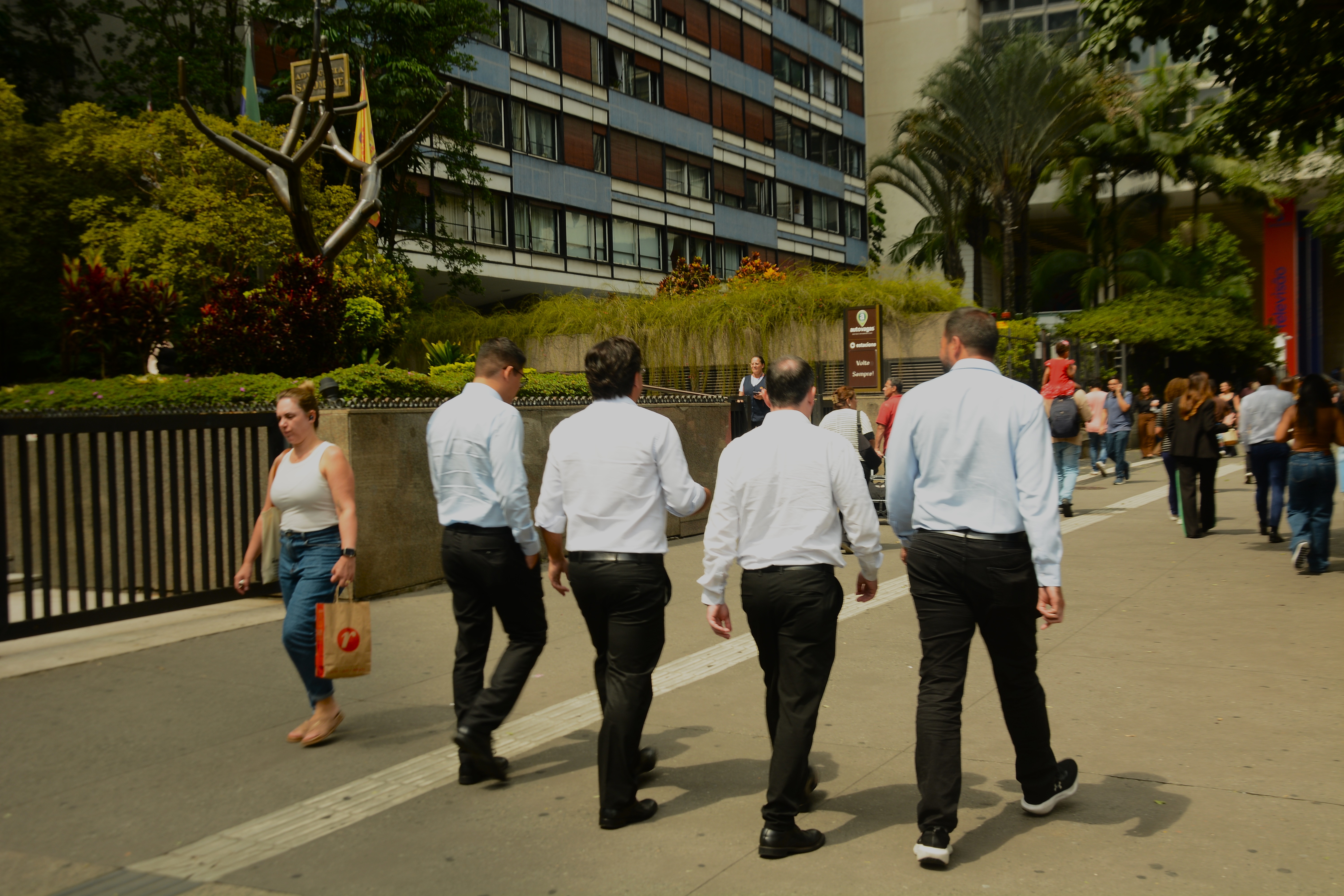 Quatro homens em trajes sociais andam lado a lado na Av. Paulista - Foto: Heitor Landim / Agenzia