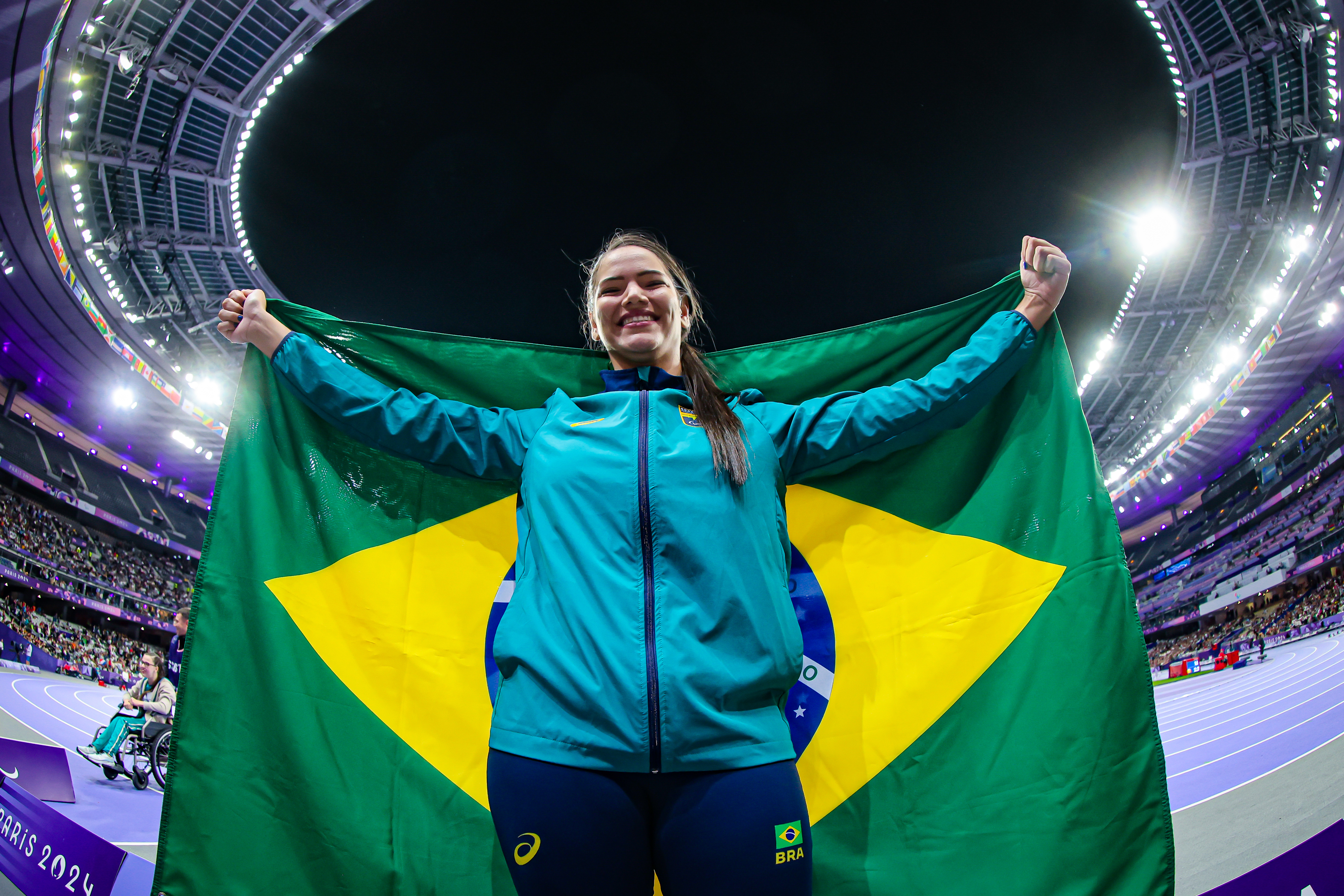 Wanna Brito carregando a bandeira do brasil durante as Paraolimpíadas de Paris 2024