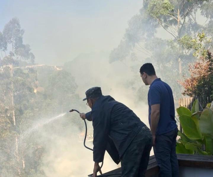 Dois homens apagando um incêndio, impulsionado por altas temperaturas. 